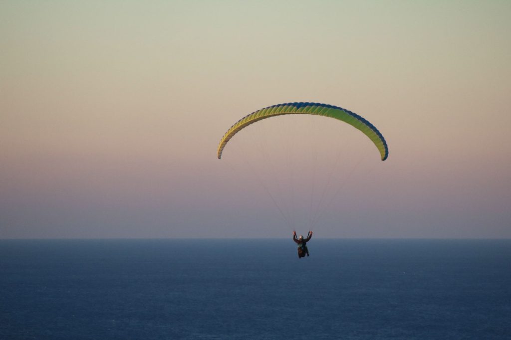 paragliding-over-ocean-at-sunset
